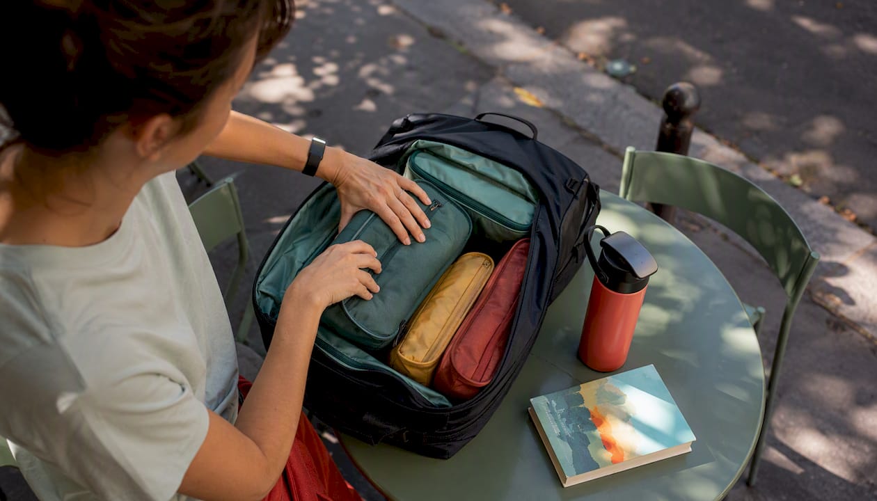 Hands organizing packing cubes in suitcase